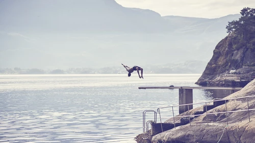 man jumping from bridge in a fjord