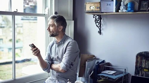 mature-businessman-using-phone-in-home-office
