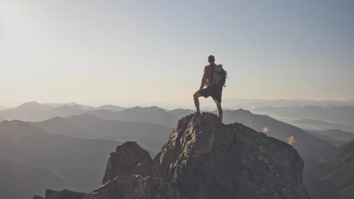 Backpacker standing on mountain peak