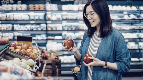 A woman shopping for fresh organic fruits in supermarket
