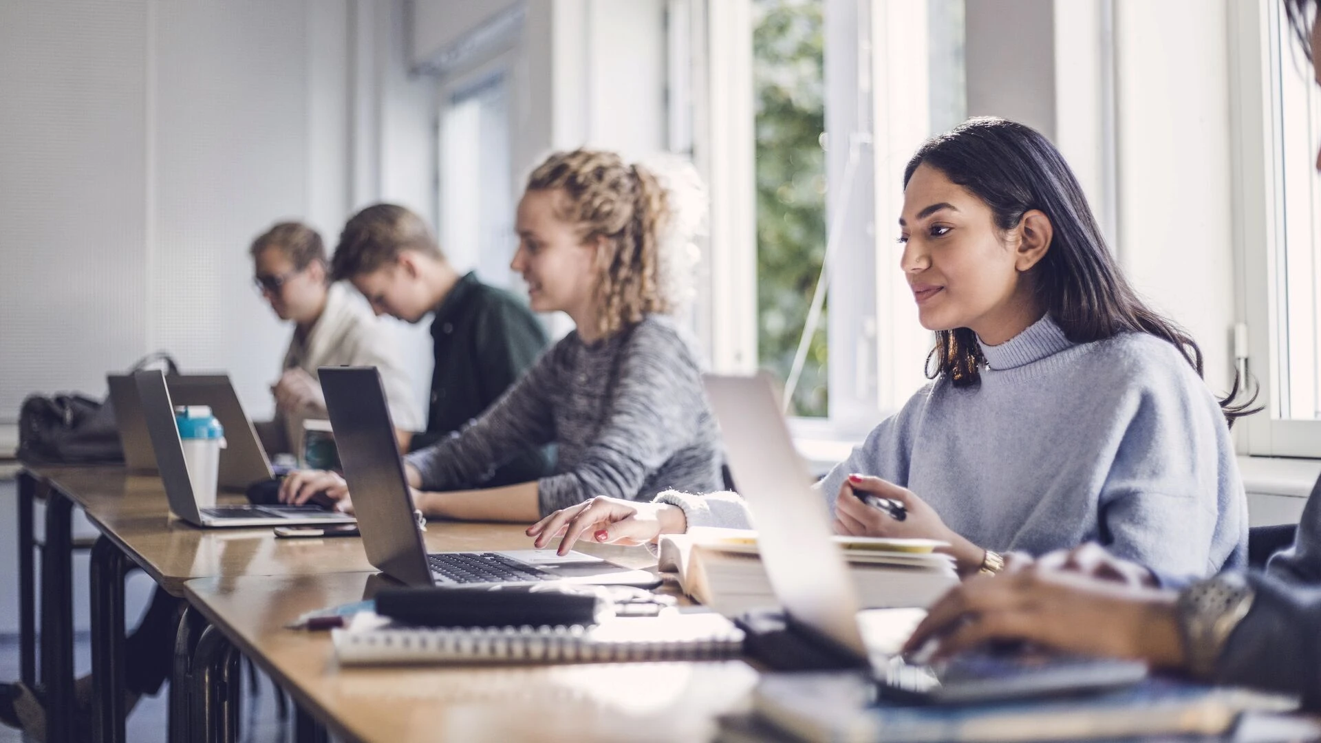 /male-and-female-students-using-laptops-in-classroom.